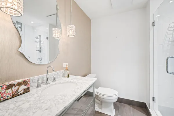 a bathroom with a granite countertop sink mirror vanity and toilet