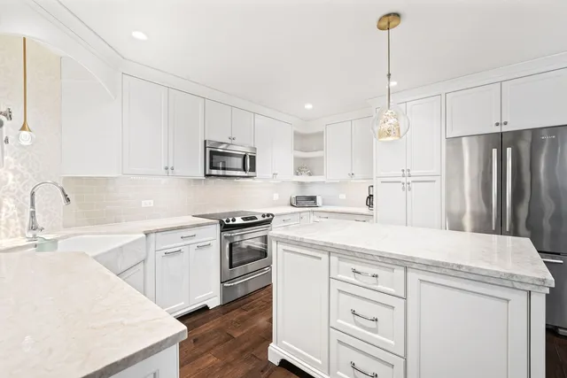 a kitchen with white cabinets stainless steel appliances and sink