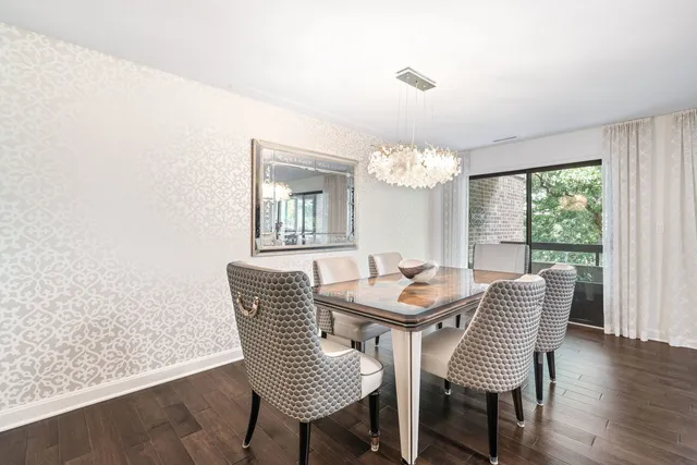 a dining room with furniture a chandelier and wooden floor