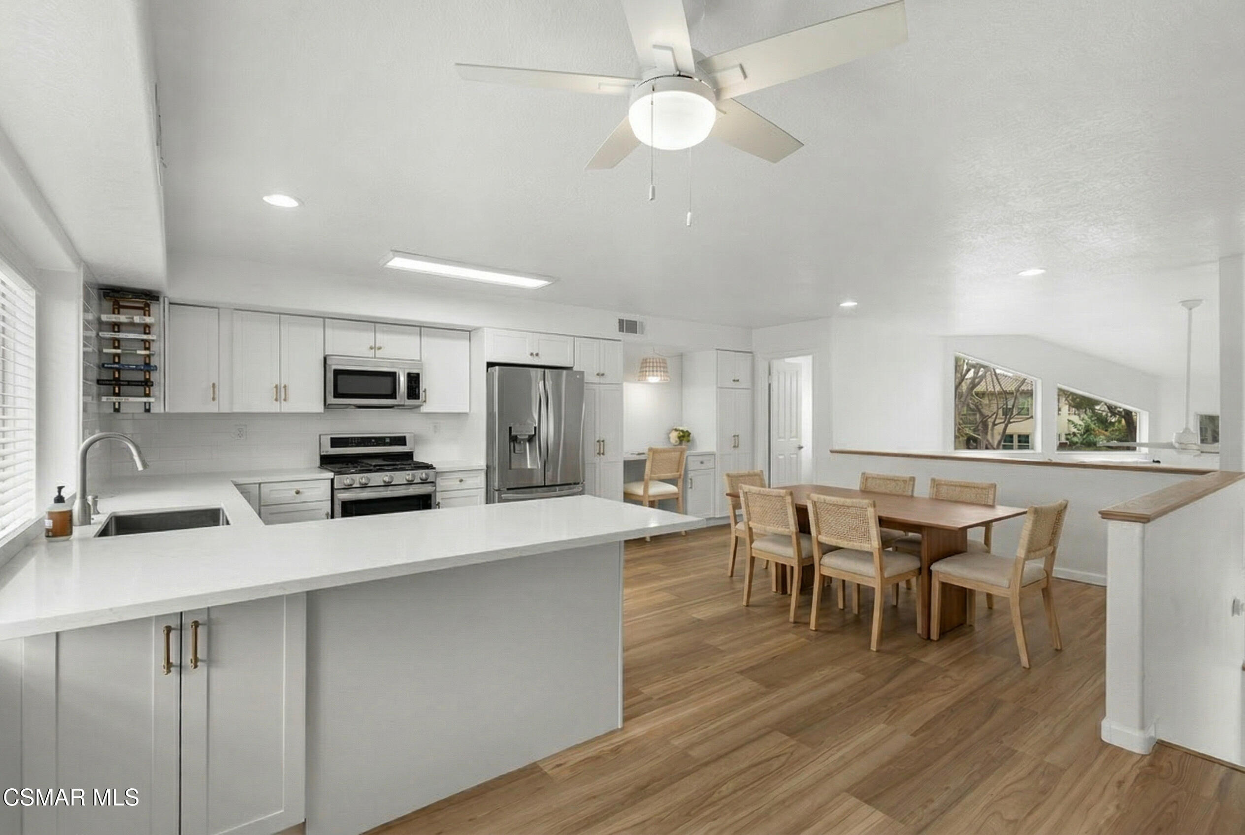 489 4th Place Port Hueneme, CA 93041 - Photo 7 of 34 a kitchen with stainless steel appliances a kitchen island hardwood floor sink stove dining table and chairs