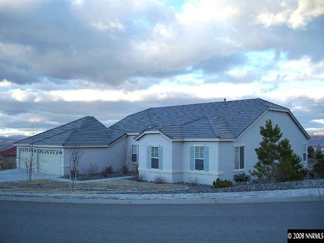 a front view of a house with a garden and trees