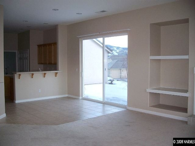 5585 North White Sands Road Reno, NV 89511 - Photo 4 of 9 an empty room with wooden floor and windows