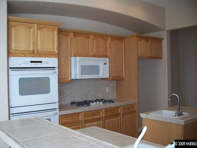 5585 North White Sands Road Reno, NV 89511 - Photo 5 of 9 a kitchen with a stove and a microwave
