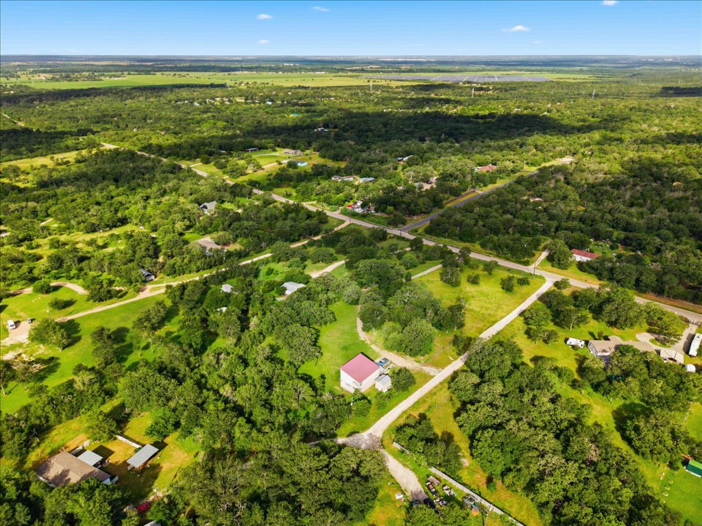 211 Webberwood Way Elgin, TX 78621 - Photo 4 of 10 An aerial perspective reveals a vast, tree-filled landscape with scattered homes and clear roadways.