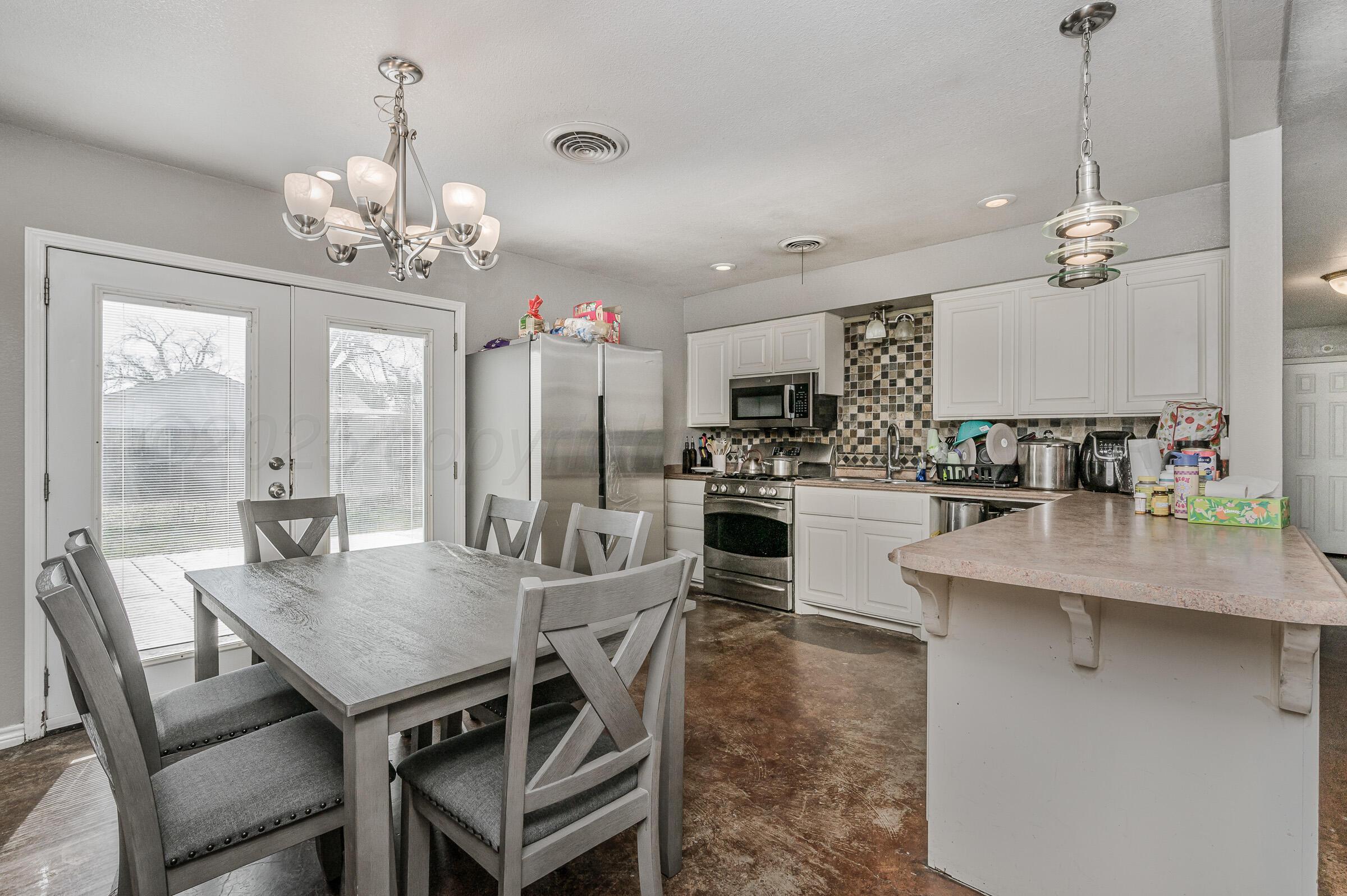 4351 South Tyler Street Amarillo, TX 79110 - Photo 6 of 18 a view of a dining room with furniture a chandelier and wooden floor