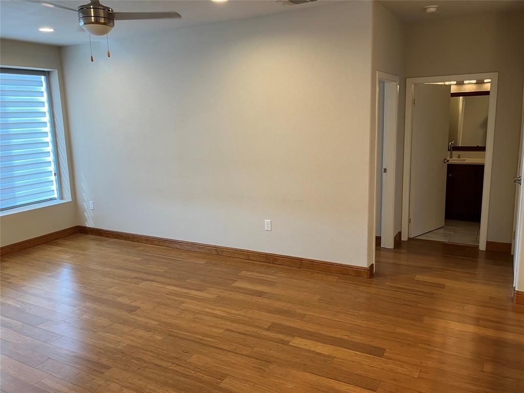 1220 West Trinity Mills Road, Unit 5009 Carrollton, TX 75006 - Photo 18 of 25 an empty room with wooden floor and windows