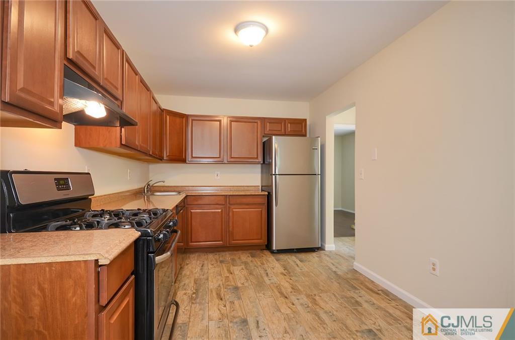 1401 Plymouth Road North Brunswick, NJ 08902 - Photo 5 of 25 a kitchen with a refrigerator and a stove