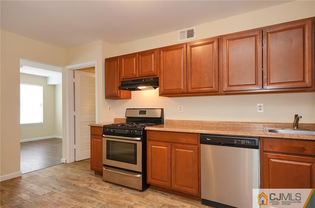 1401 Plymouth Road North Brunswick, NJ 08902 - Photo 6 of 25 a kitchen with stainless steel appliances granite countertop a stove a sink and a microwave
