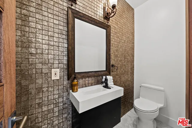 a bathroom with a sink a toilet and mirror