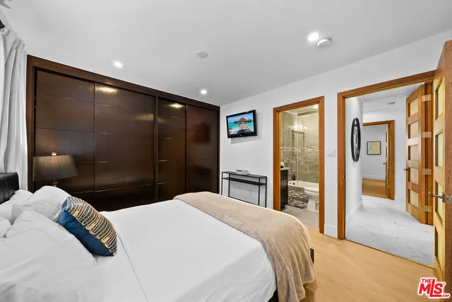 a bedroom with a large bed and a walk in closet