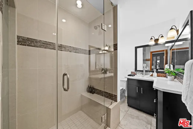 a bathroom with a double vanity sink a mirror and shower