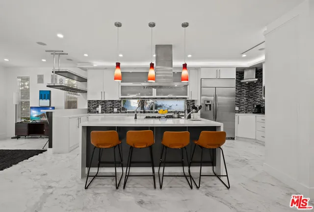 a kitchen with stainless steel appliances granite countertop a sink and chairs