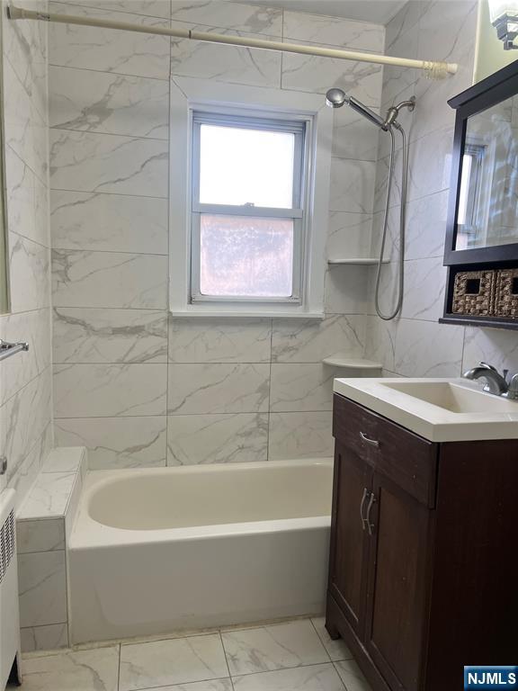 715 Broad Avenue, Unit 2A Ridgefield, NJ 07657 - Photo 11 of 12 a bathroom with a sink vanity mirror bathtub and shower