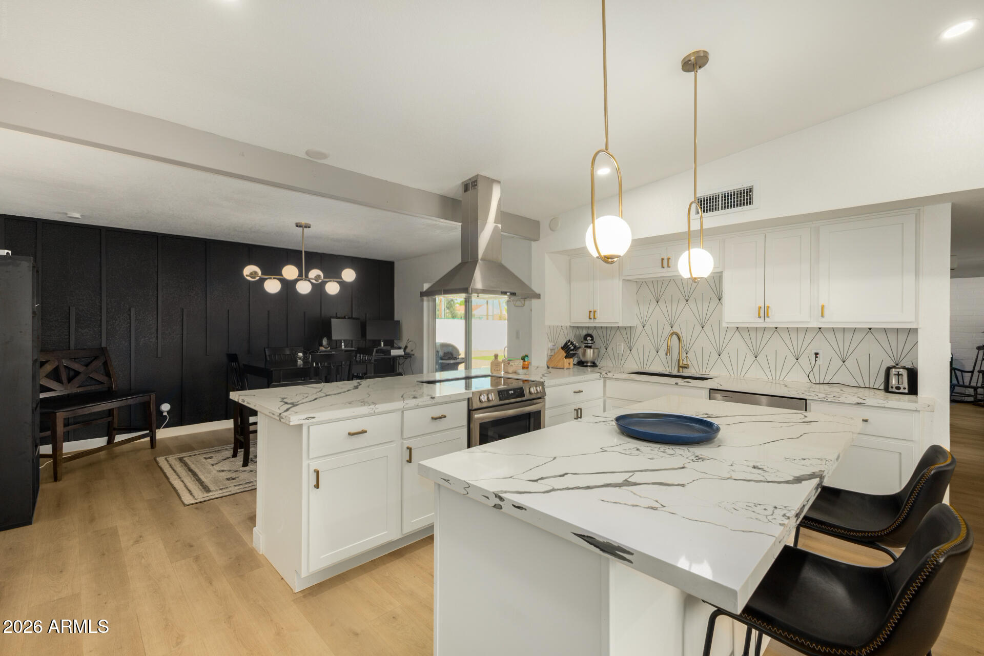 1560 North Freeman Mesa, AZ 85201 - Photo 5 of 22 a kitchen with a stove a sink a kitchen island with chairs and cabinets