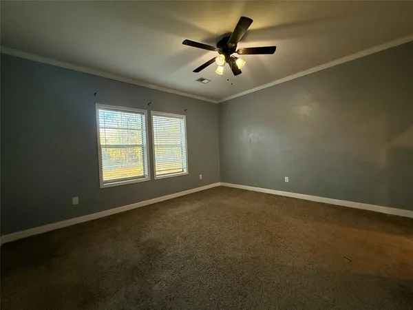 an empty room with a window and a fan