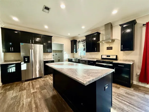 a kitchen with stainless steel appliances granite countertop a stove refrigerator and sink