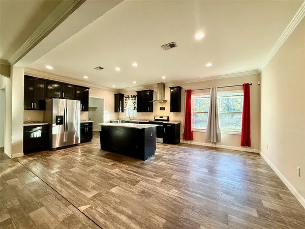a view of kitchen with stainless steel appliances kitchen island granite countertop a refrigerator and a stove top oven