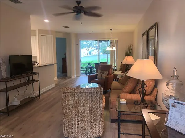 a living room with furniture a flat screen tv and a large window