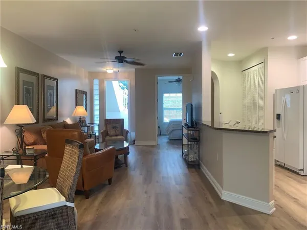 a living room with furniture a wooden floor and a chandelier