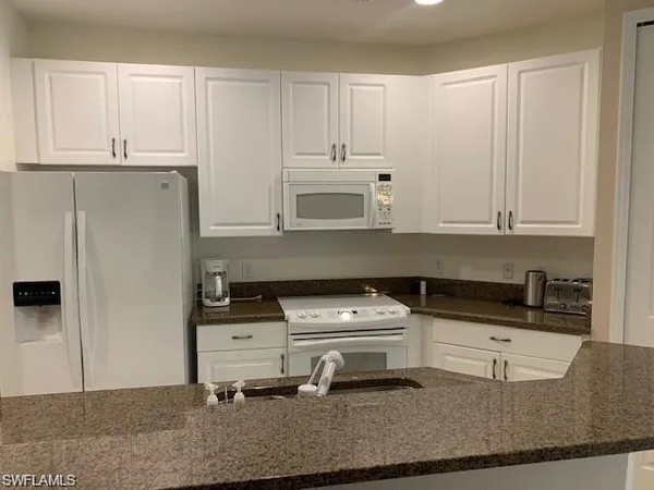 a room with granite countertop a stove a sink and a granite counter tops