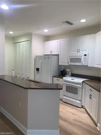 a kitchen with granite countertop a sink and cabinets