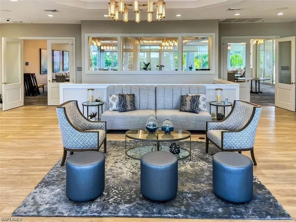 a living room with furniture a large window and a chandelier