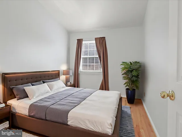 a bedroom with a bed and a potted plant
