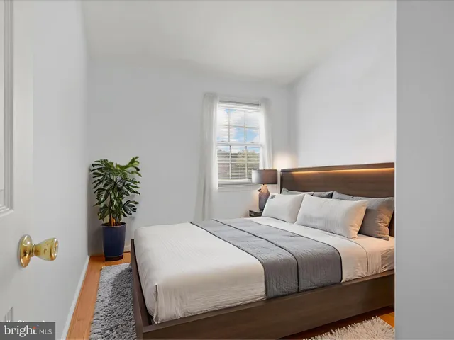 a bedroom with a bed and a potted plant