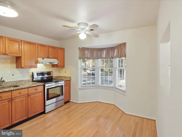 a kitchen with stainless steel appliances granite countertop a stove a sink dishwasher and a microwave oven with cabinets