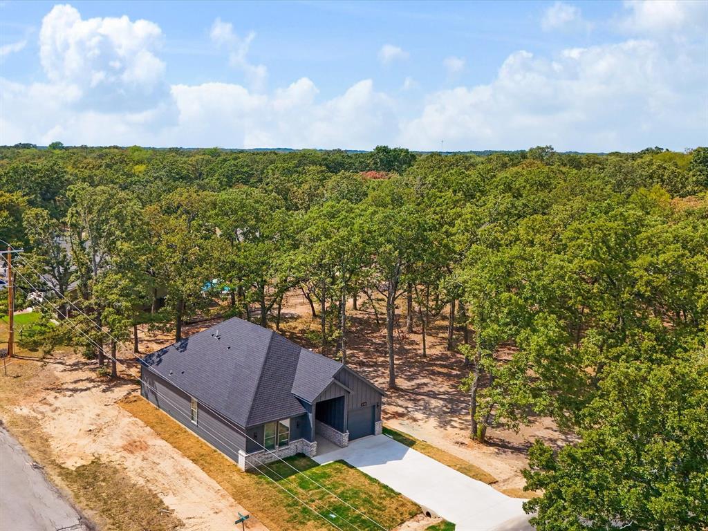 4705 Point La Vista Road Malakoff, TX 75148 - Photo 34 of 40 Modern home exterior with dark siding, light stone accents, and a dark shingle roof