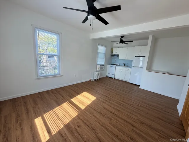 a view of empty room with wooden floor and window