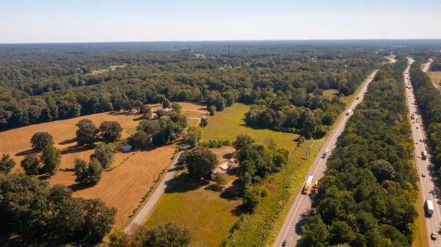 an aerial view of house with yard and mountain view in back