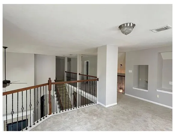 a view of a hallway with a chandelier fan