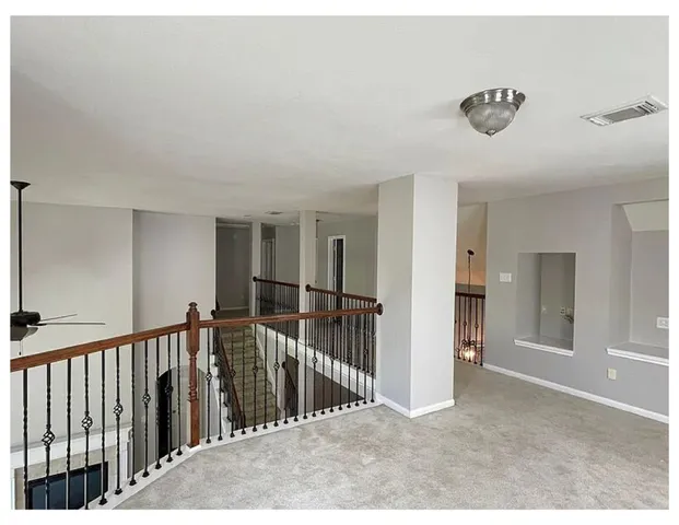 a view of a hallway with a chandelier fan