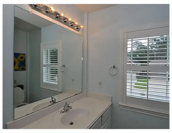 a bathroom with a granite countertop sink a mirror and a shower