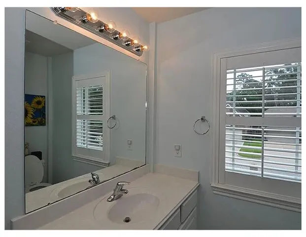 a bathroom with a granite countertop sink a mirror and a shower