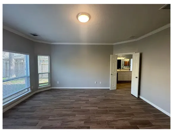 a view of an empty room and window and wooden floor