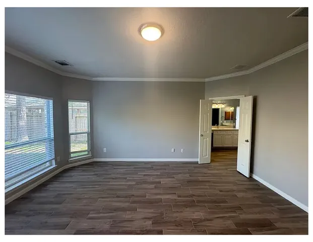 a view of an empty room and window and wooden floor