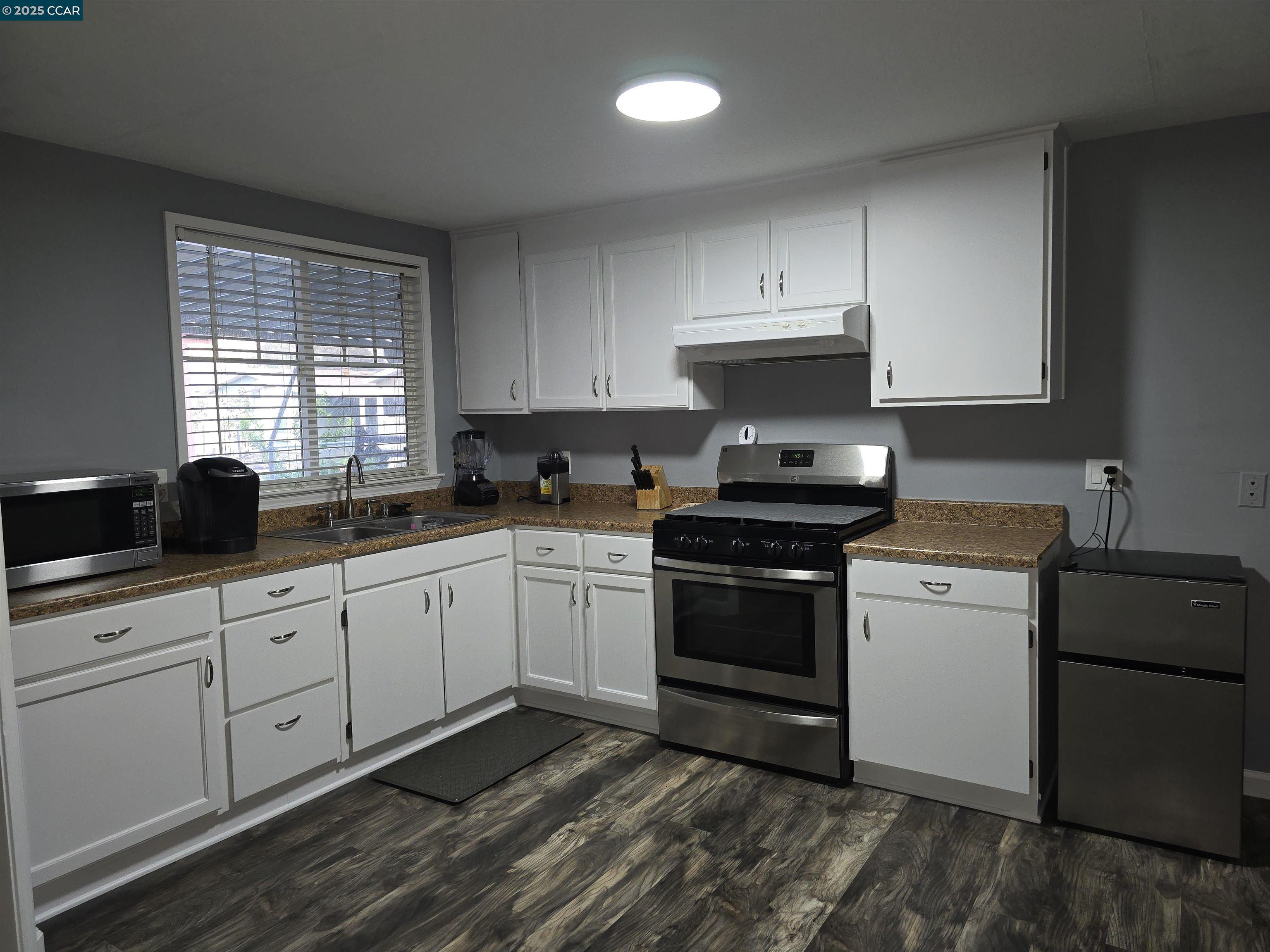 16711 Marsh Creek Road, Unit 112 Clayton, CA 94517 - Photo 15 of 30 a kitchen with granite countertop white cabinets and white appliances