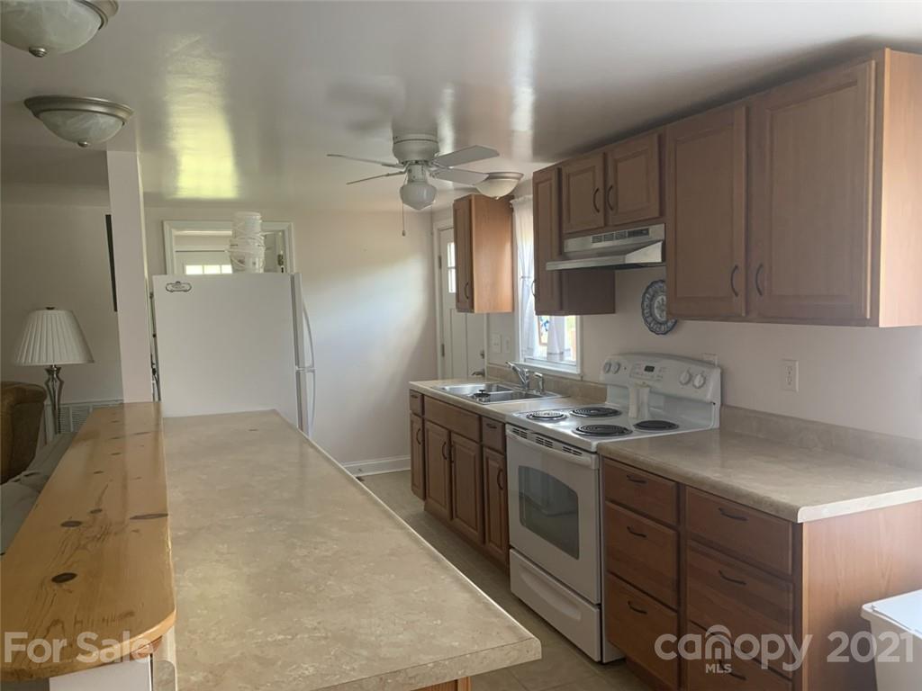 1822 Sharon Road York, SC 29745 - Photo 24 of 39 a kitchen with stainless steel appliances granite countertop a stove a sink dishwasher and a refrigerator with wooden cabinets