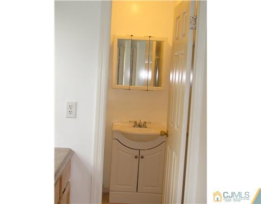 71 Sturgis Road Edison, NJ 08817 - Photo 8 of 11 a bathroom with a sink a toilet and mirror