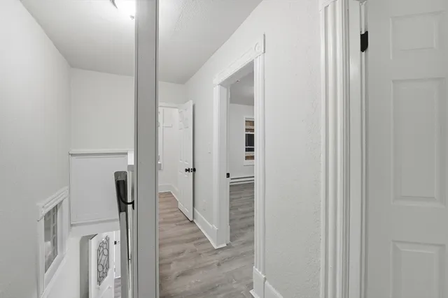 a view of a hallway with wooden floor and staircase