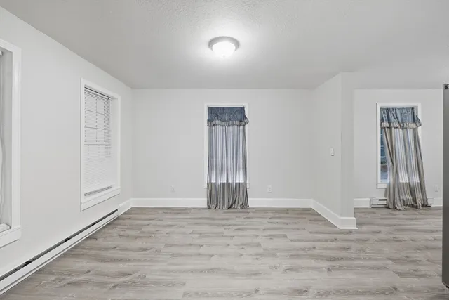 an empty room with wooden floor and a window