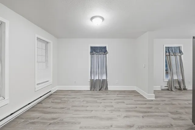 an empty room with wooden floor and a window