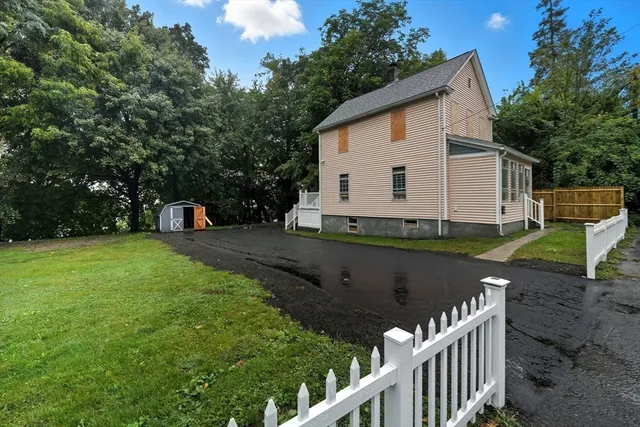a view of a house with backyard and sitting area