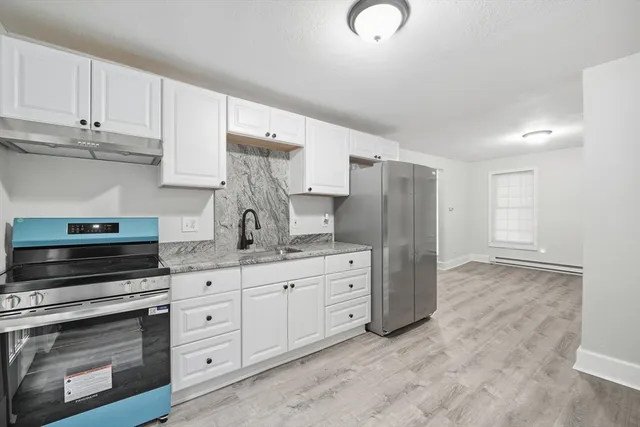a kitchen with white cabinets and stainless steel appliances