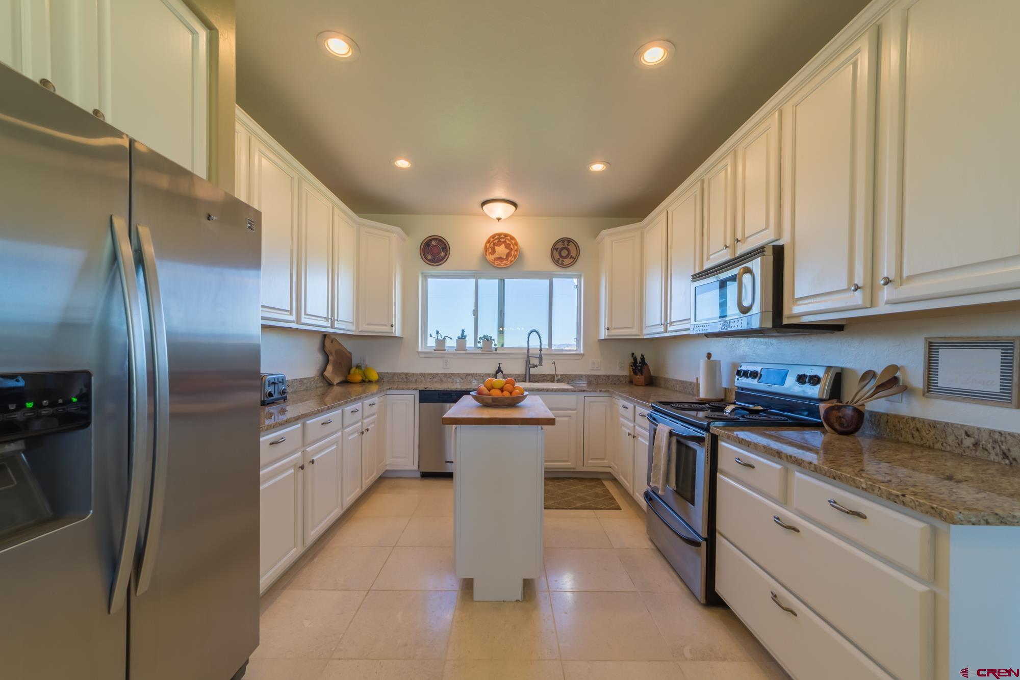68041 Ute Vly Drive Montrose, CO 81403 - Photo 14 of 35 a kitchen with stainless steel appliances granite countertop a sink a stove and a refrigerator