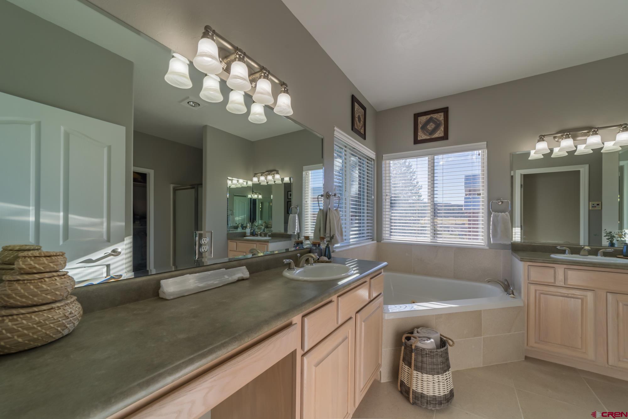 68041 Ute Vly Drive Montrose, CO 81403 - Photo 17 of 35 a spacious bathroom with a granite countertop sink a large mirror and a bathtub
