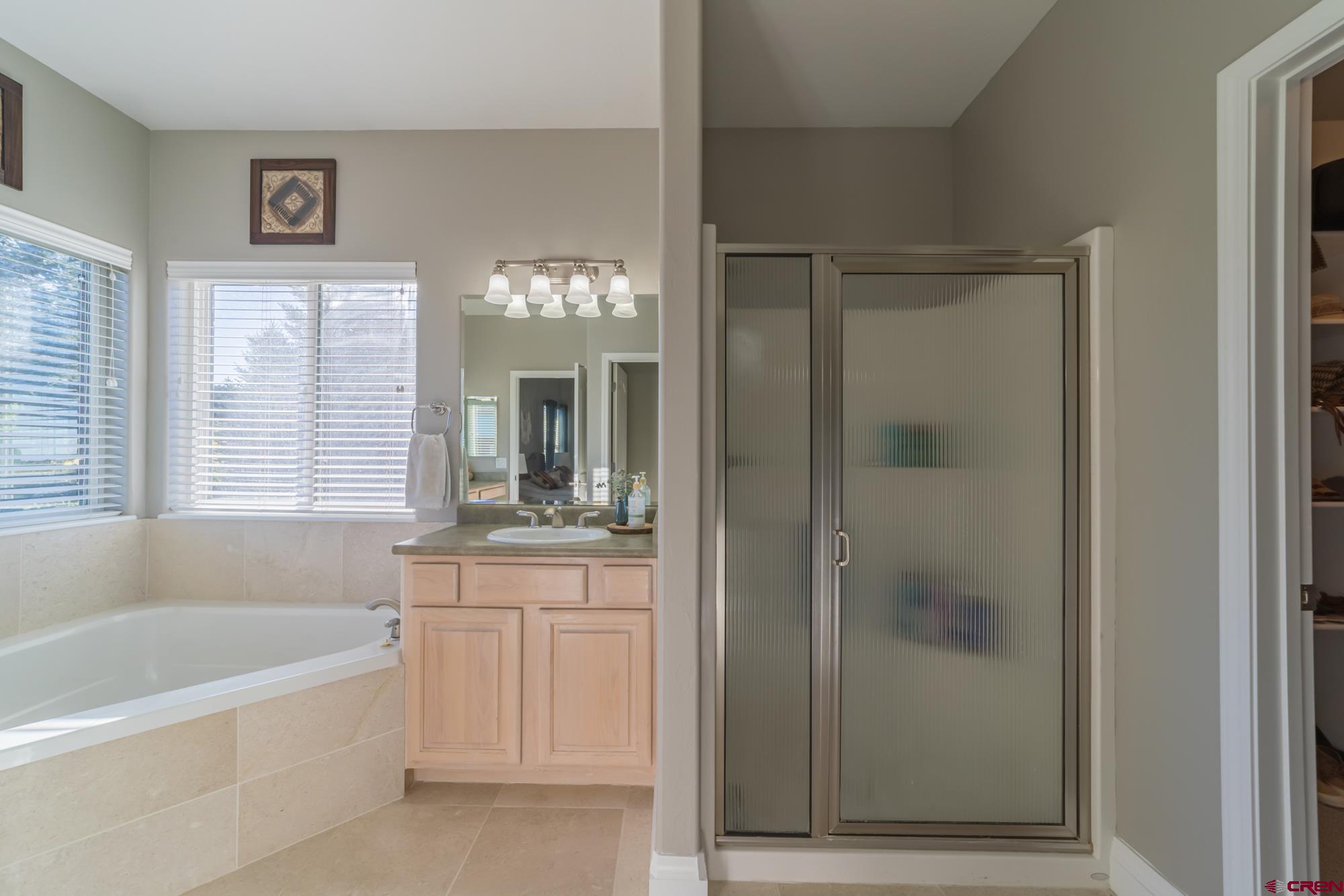 68041 Ute Vly Drive Montrose, CO 81403 - Photo 18 of 35 a bathroom with a tub a sink and mirrors