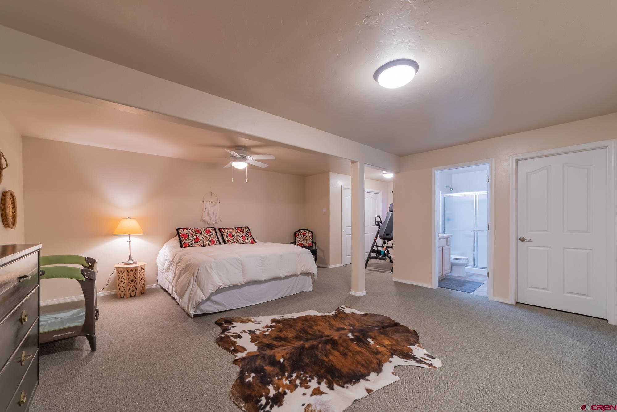 68041 Ute Vly Drive Montrose, CO 81403 - Photo 26 of 35 a spacious bedroom with a bed and a lamp